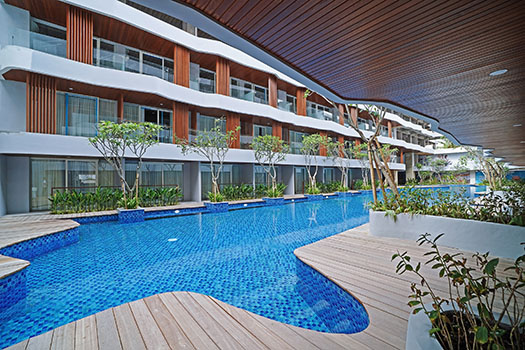 Wyndham Garden Kuta Beach resort with poolside and building view.